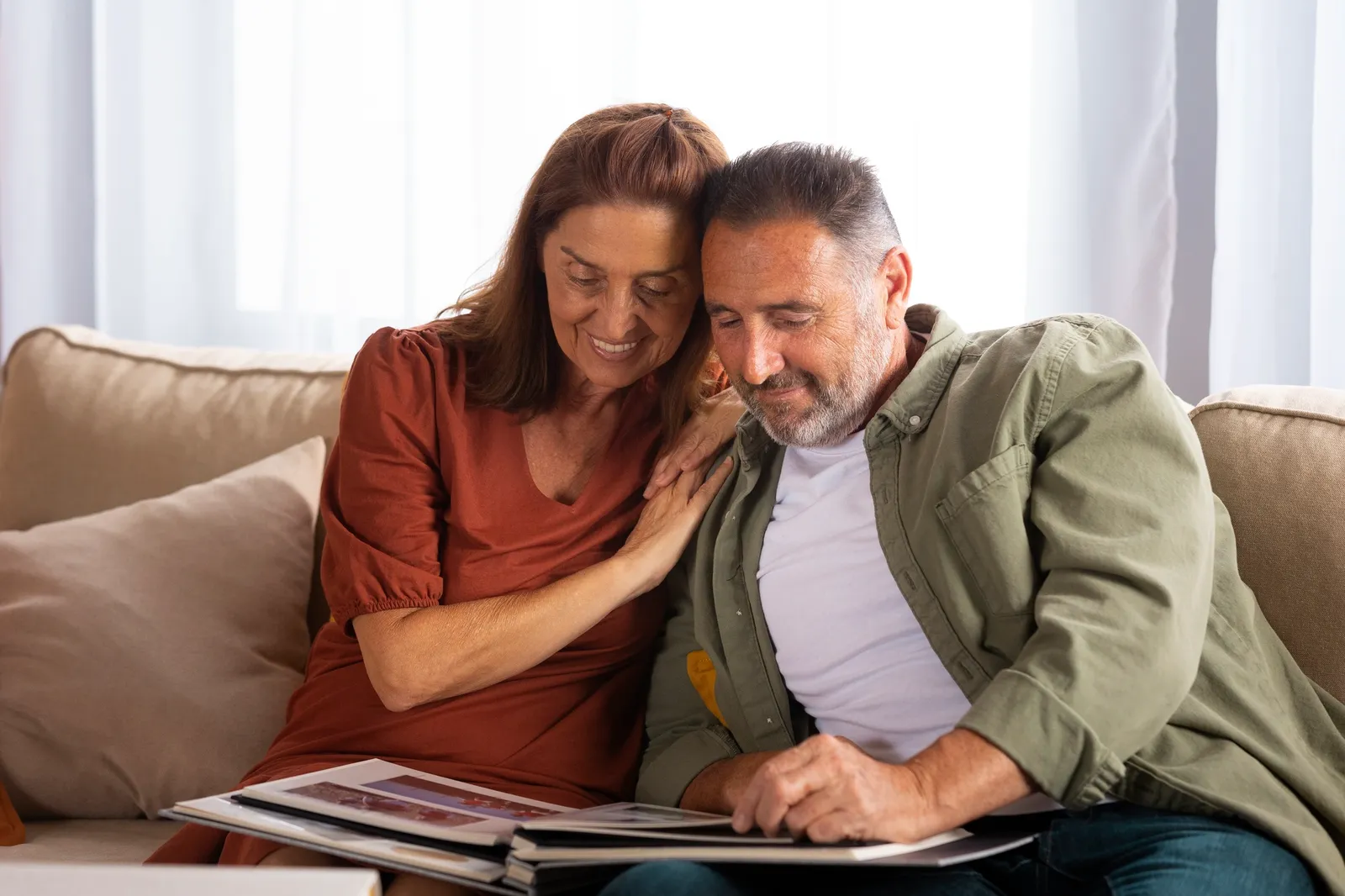 A couple reading a document together on the sofa