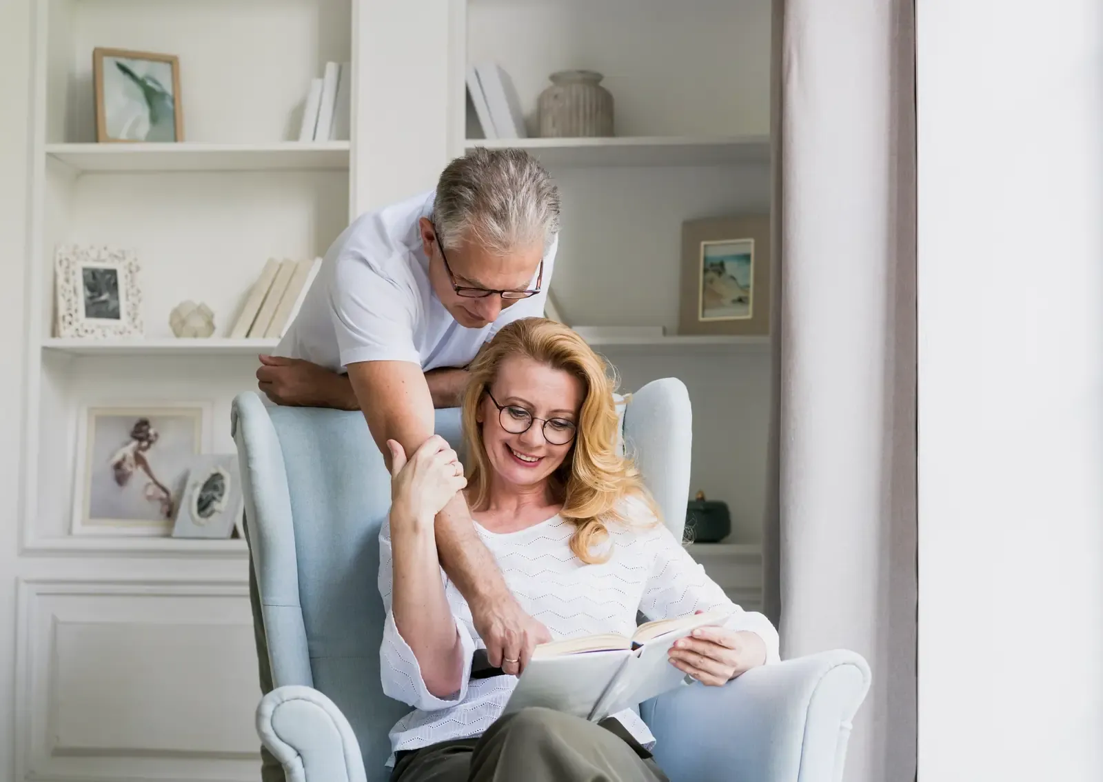 A retired couple reading together in their living room